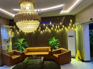 a living room with a couch and a chandelier at Chillers Hotel and Suites in Aiyetoto-Asogun