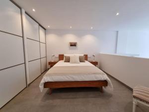 um quarto com uma cama grande e paredes brancas em Loft Filipinas Vibes Coruña em La Coruña