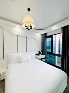 una camera con un letto bianco e una grande finestra di SALA HOTEL HUE a Hue