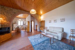 a living room with a couch and a tv at Agriturismo il Palagetto in Pomarance