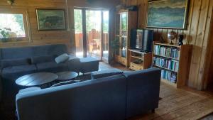 a living room with a couch and a tv at Koliba Drabsko in Lom nad Rimavicou