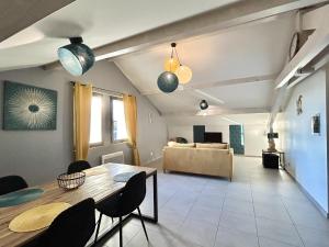 ein Wohnzimmer mit einem Tisch, Stühlen und einem Sofa in der Unterkunft M48 *Marquer* T2 atypique Cranves-Sales in Cranves-Sales