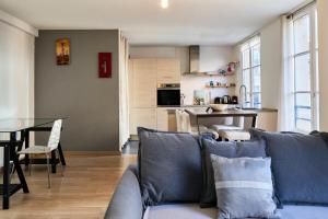 un salon avec un canapé bleu et une cuisine dans l'établissement Vieux-Lille equipped apartment with parking, à Lille