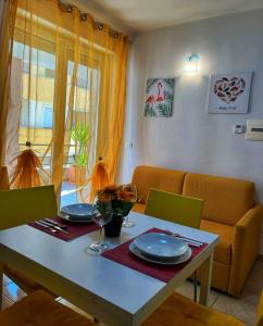 une table de salle à manger avec des assiettes et des verres dessus dans l'établissement Andrea House, à Lecce