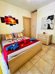 une chambre avec un grand lit avec des animaux en peluche bleus dessus dans l'établissement Andrea House, à Lecce