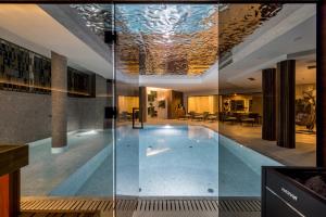 a swimming pool in a building with glass walls at Hotel Fanat in Split