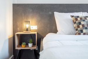 a bedroom with two beds and a table with a lamp at Hypercentre: apartment near station with parking in Lille