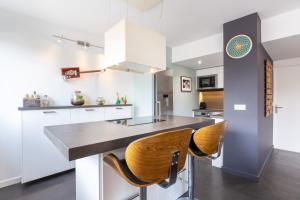 a kitchen with white cabinets and a wooden counter top at Hypercentre: apartment near station with parking in Lille