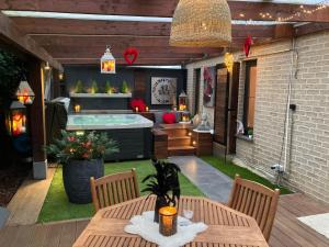 a patio with a hot tub and a table and chairs at Le Nid d'Ange in Ohey