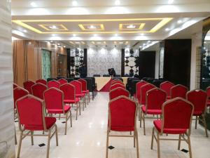 een vergaderzaal met rode stoelen en een tafel bij Adarsha Palace Hotel in Chuknagar