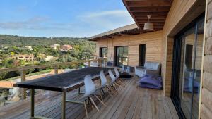 una terraza de madera con mesa y sillas. en Villa LilieKaena, en Albitreccia