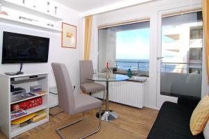 ein Wohnzimmer mit einem Tisch und Meerblick in der Unterkunft Haus am Meer, Whg 110, Seeseite in Westerland