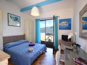 a bedroom with a bed with a table and a desk at Résidence Maquis Bella Vista in Propriano