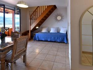 a bedroom with a bed with blue sheets and a staircase at Résidence Maquis Bella Vista in Propriano