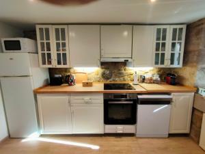 a kitchen with white cabinets and white appliances at O Rincón de Esther in Vedra +13 photos