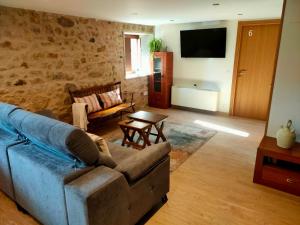 a living room with a couch and a tv at O Rincón de Esther in Vedra