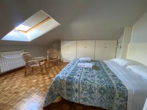 1 Schlafzimmer mit einem großen Bett und 2 Stühlen in der Unterkunft La terrazza sul tetto in Porto San Giorgio