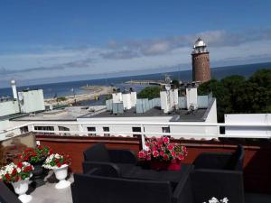 a balcony with chairs and a lighthouse on a building at Apartament z Widokiem na Morze w Kołobrzegu in Kołobrzeg
