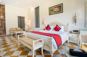 een slaapkamer met een groot wit bed met rode kussens bij Spree Resort Sariska in Thāna Ghāzi