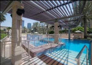 a swimming pool with a pergola next to a swimming pool at Urban 3BR at Al Mesk Tower Dubai Marina in Dubai