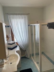 een witte badkamer met een douche en een wastafel bij Casa Ducati in Riva del Garda