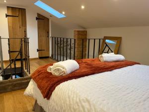 a bedroom with a bed with two towels on it at The Forge in Towcester