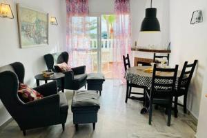 een woonkamer met een tafel en stoelen en een eetkamer bij Apartamento con piscina en Las Rosas de Capistrano in Nerja