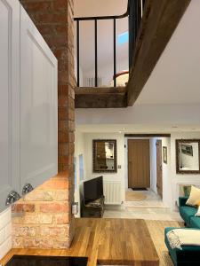 a living room with a brick wall and a couch at The Forge in Towcester