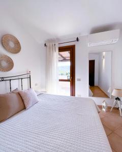 a bedroom with a large white bed with a window at Casa Carmen - Attico vista mare in Porto San Paolo