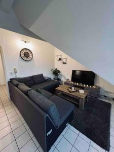 a living room with a couch and a tv at Appartement net buiten stadskern in Hasselt