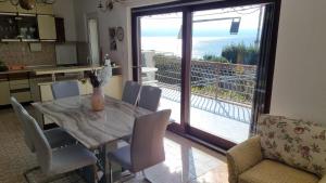 a kitchen and dining room with a table and a balcony at Apartments Villa Tanja in Podstrana