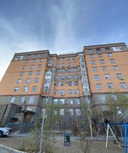 a large brick building with a playground in front of it at Квартира в центре города,в ЖК Куралай in Qyzylorda