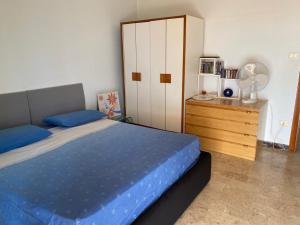 um quarto com uma cama e uma cómoda com uma ventoinha em Frontemare em Crotone