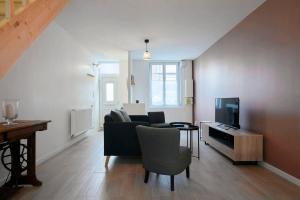 a living room with a couch and a tv at House in Lille near Euratech private terrace. in Lille