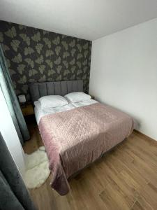 a bedroom with a bed and a wall at Apartament Szary 14/2 in Starogard Gdański