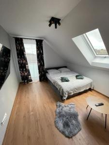 a bedroom with a bed and a table and windows at Apartament Szary 14/2 in Starogard Gdański
