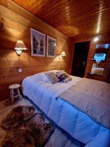 1 dormitorio con 1 cama grande en una habitación de madera en Chalet les Jales Jacuzzi et étang !, en Gerbépal