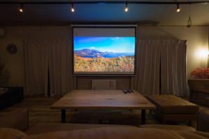 a large screen in a living room with a table at 箱根仙石原を大勢で遊びたい &癒されたい in Sengokuhara