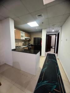 eine Küche mit einer schwarzen Arbeitsplatte in einem Zimmer in der Unterkunft furnished apart in city tower in Ajman 