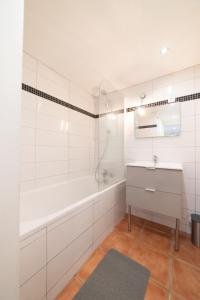 梅濟約的住宿－Appartement Gardhenn Stadium LCLD Arena Groupama Lyon，白色的浴室设有浴缸和水槽。