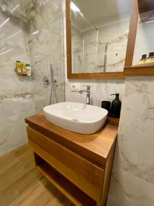 bagno con lavandino bianco e specchio di Olimian Retreat Rosa 421 a Podcetrtek