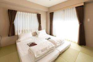 東京にある灯光旅館 Light hotelの窓付きの客室で、白い大型ベッド1台が備わります。