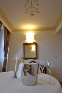 a table with two wine glasses and a mirror at Palazzo Riccucci in Montappone