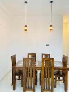 a dining room with a wooden table and chairs at Happy Haven in Hikkaduwa +8 photos