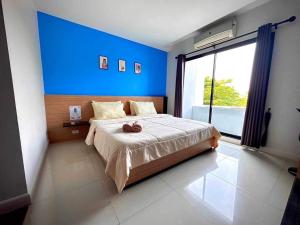 1 dormitorio con 1 cama grande y pared azul en I Hotel Khonkaen en Khon Kaen