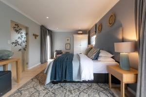 a bedroom with a bed with a blue blanket at Mes Amis Beach Guest House in Wilderness