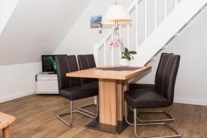 uma sala de jantar com uma mesa e quatro cadeiras em Haus Szameit, Whg 3 em Süderende