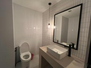 uma casa de banho com um WC, um lavatório e um espelho. em Keep Aonang em Praia de Aonang