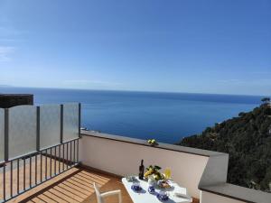 a balcony with a table and a view of the ocean at Piccola Perla in Amalfi