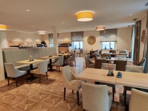 a restaurant with tables and chairs and a bar at Hotel Lutz in Rain